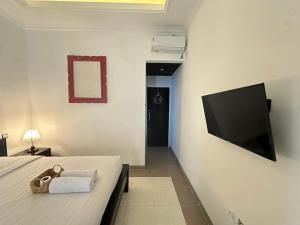 SampalanにあるLittle White Pavilionのベッドと薄型テレビのある寝室