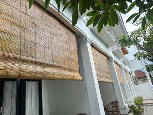 SampalanにあるLittle White Pavilionの側面に大きな籐のシェードが付いた建物