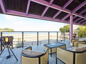 a porch with chairs and a table and a view of the beach at 真砂悠々庵 in Minamichita