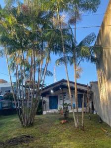 a house with palm trees in front of it at Chalé Praia Doce in Belém