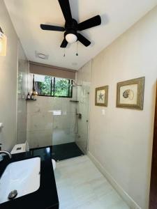 a bathroom with a ceiling fan and a shower at Hotel Boutique Bahia Esmeralda in Potrero