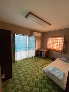 a room with a bed and a desk and two windows at kumanonisumu! in Kumano