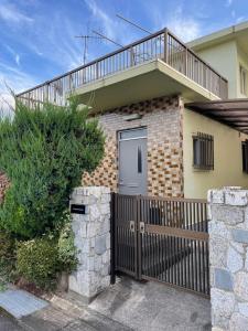 a house with a wooden gate and a balcony at kumanonisumu! in Kumano
