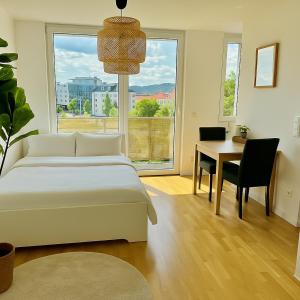 a bedroom with a bed and a desk and a window at Modern Apartment with Balcony near Vienna in Wiener Neudorf