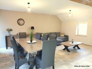 a dining room with a table and a couch at Gîte HUGO Domaine de la Pierre - FR-1-489-339 in Thiel-sur-Acolin