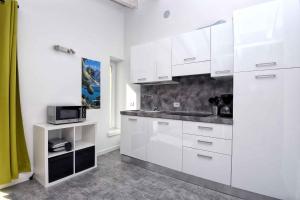a white kitchen with white cabinets and a microwave at Apartments in Tremosine sul Garda 34645 in Tremosine Sul Garda +37 photos