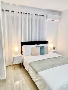 a bedroom with a large bed with white curtains at Rich Villa Guesthouse in Bayamon +42 photos
