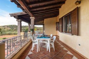 Un patio con una mesa y sillas en un balcón. en House and Apts. Siniscola - Sardinien 35758, en Santa Lucia