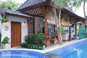 a villa with a swimming pool and a house at Tasola Boutique Hotel in Sorongjukung