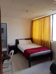 1 dormitorio con 1 cama con cortina amarilla en Hotel Galerias, en Ruiosucio