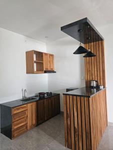 a kitchen with wooden cabinets and a black counter top at BBC Suites and Garden in Uluwatu