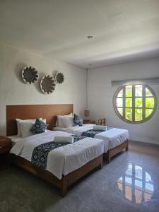 a bedroom with three beds and a window at BBC Suites and Garden in Uluwatu +18 photos
