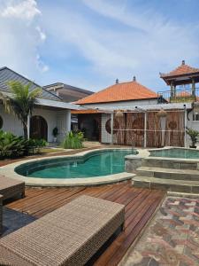 a swimming pool in a yard with a house at BBC Suites and Garden in Uluwatu