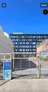 a parking lot with a fence and a building at CBD Gem Cooling Summer and City View in Wellington