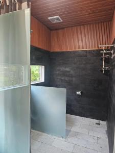 a bathroom with black walls and a window at BBC Suites and Garden in Uluwatu