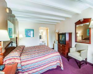 a hotel room with a bed and a tv and a chair at Econo Lodge Galax in Galax +10 photos