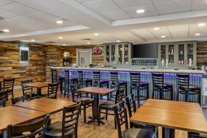a restaurant with wooden tables and chairs and a bar at The Angler Hotel Livingston, an Ascend Collection Hotel in Livingston
