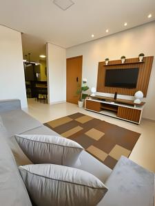 a living room with two beds and a flat screen tv at SQ131A Moderno e Aconchegante in Goiânia