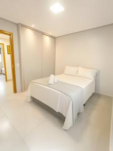 a white bedroom with a white bed in it at SQ131A Moderno e Aconchegante in Goiânia