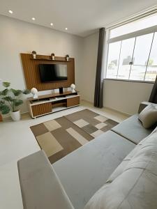 a living room with a couch and a television at SQ131A Moderno e Aconchegante in Goiânia +18 photos