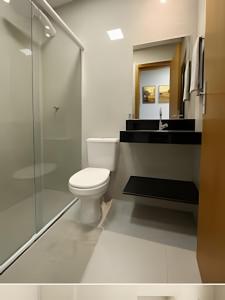 a bathroom with a toilet and a glass shower at SQ131A Moderno e Aconchegante in Goiânia