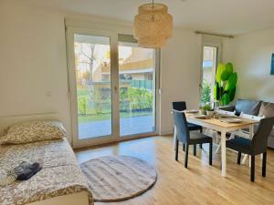 een slaapkamer met een bed en een tafel met stoelen bij Modern Apartment with Terrace Patio in Wiener Neudorf