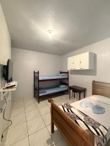 a bedroom with a bed and a desk and a television at Pousada São José in Itatiaia