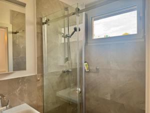 een badkamer met een glazen douche met wastafel bij Modern Apartment with Terrace Patio in Wiener Neudorf +92 foto's