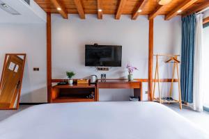 een slaapkamer met een bed en een tv aan de muur bij Phoenix Mountain View Courtyard Homestay in Fenghuang