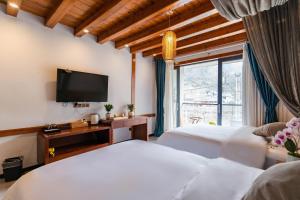 een slaapkamer met twee bedden en een flatscreen-tv bij Phoenix Mountain View Courtyard Homestay in Fenghuang +59 foto's