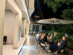 een groep mensen aan een tafel met een paraplu bij Phoenix Mountain View Courtyard Homestay in Fenghuang