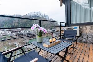 een balkon met een tafel en stoelen en uitzicht bij Phoenix Mountain View Courtyard Homestay in Fenghuang