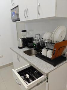 a kitchen with a sink and a counter with dishes at Habitacion con entrada independiente y aire acondicionado, Centro Piura in Piura