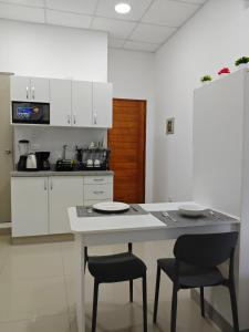 a kitchen with a white table and two chairs at Habitacion con entrada independiente y aire acondicionado, Centro Piura in Piura