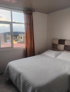 a bedroom with a bed and a large window at Hotel Iraca in Aquitania