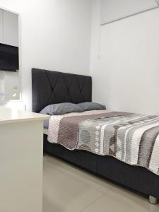 a bed with a black headboard in a room at Habitacion con entrada independiente y aire acondicionado, Centro Piura in Piura