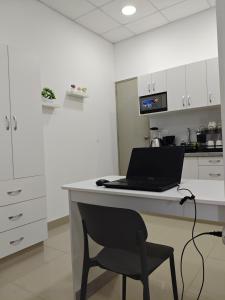 a laptop computer sitting on a desk in a kitchen at Habitacion con entrada independiente y aire acondicionado, Centro Piura in Piura +12 photos
