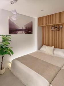 een slaapkamer met een groot bed en een potplant bij 서울 stay moon 종로 혜화 경복궁 SKKU 명동 DDP 광장시장 인사동 낙산공원 KPDH in Seoul