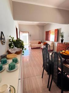 eine Küche und ein Wohnzimmer mit Tisch und Stühlen in der Unterkunft Casa Rosales in Luis Correia
