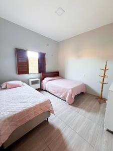 ein Schlafzimmer mit zwei Betten und einem Fenster in der Unterkunft Casa Rosales in Luis Correia + 10 Fotos