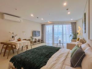 a bedroom with a large bed and a living room at Ocean Pearl The Sóng Apartment - Vung Tau City - Căn Hộ View Biển, Hồ Bơi Vô Cực in Vung Tau +136 photos