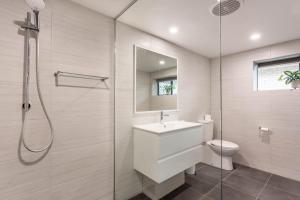 Un baño con inodoro, lavabo y ducha. en Barry's Place, en Yeppoon
