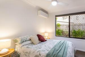 Un dormitorio con una cama y una ventana grande en Barry's Place, en Yeppoon