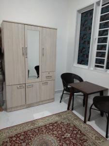 a room with a large cabinet with a table and chairs at Makwan Homestay D in Kubang Semang