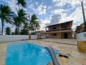 an image of a swimming pool in front of a house at Casa da Janelas Azuis Praia Azul in Pitimbu