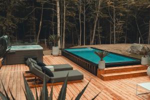 a hot tub sitting on a deck next to a wooden deck at Zen House 6 - Villas & Spa in Morin Heights