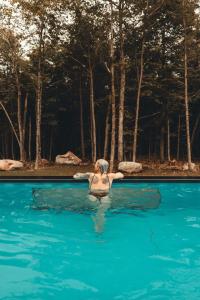 a woman in the water in a swimming pool at Zen House 6 - Villas & Spa in Morin Heights