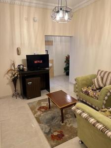 a living room with a couch and a tv at Güzellik Junior Suite جناح قوزيوليك in Abha +9 photos