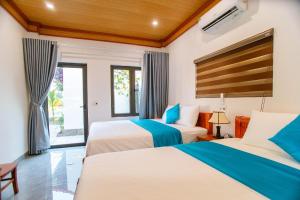 ein Schlafzimmer mit zwei Betten und einem Fenster in der Unterkunft Tam Coc Minh Quân Bungalow & Homestay in Ninh Bình + 53 Fotos