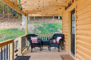 a porch of a cabin with three chairs on it at Throw'n Shade at the Red - near RRG KY in Stanton